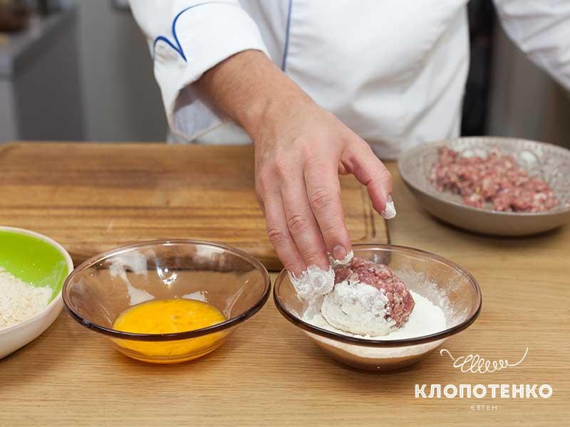 Обваляйте шарик фарша с яйцом в муке