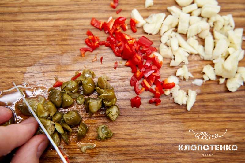 Нарежьте чеснок, чили и каперсы