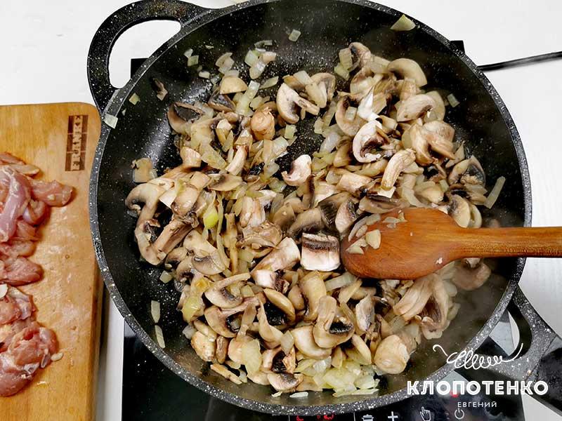 Добавьте к луку порезанные грибы