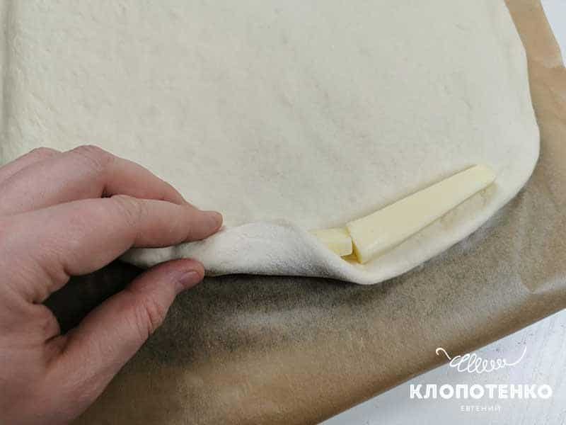 По краю основы выложите брусочки моцареллы