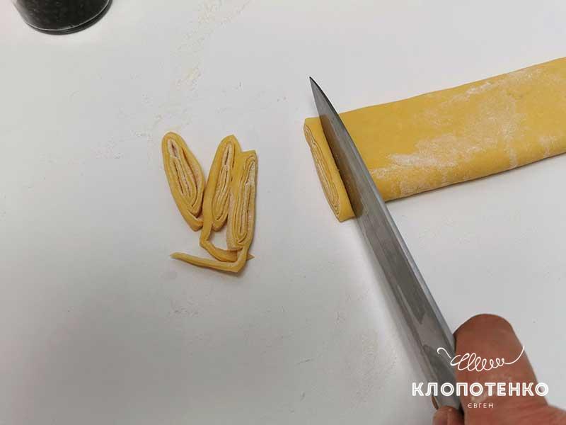 Нарежьте рулет из теста тоненькими полосками