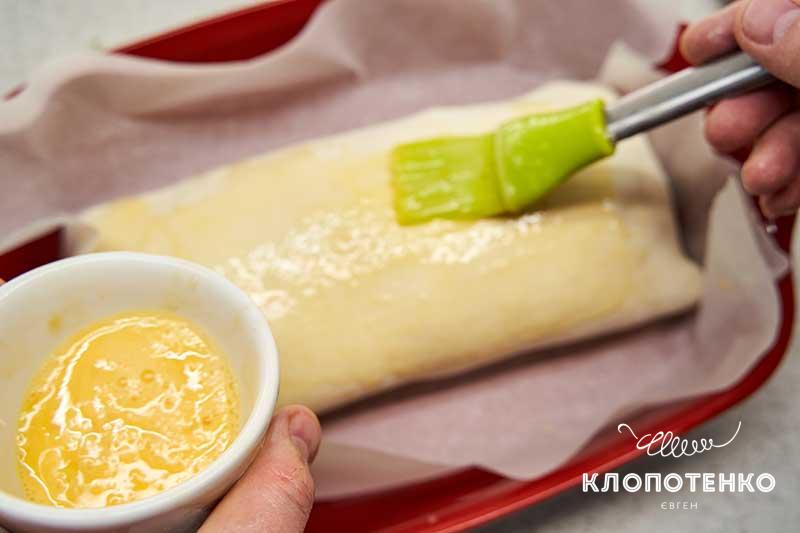 Смажьте тесто яйцом