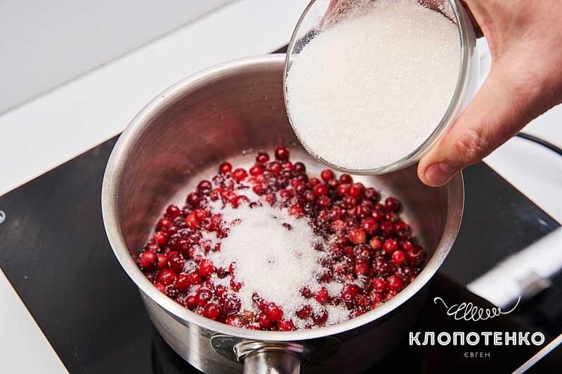 Выложите в сотейник оставшуюся клюкву и сахар