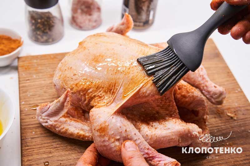 Смажьте курицу со всех сторон подсолнечным маслом