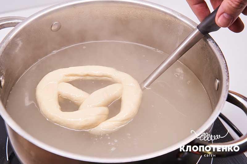 Опустите брецели в кипящую воду
