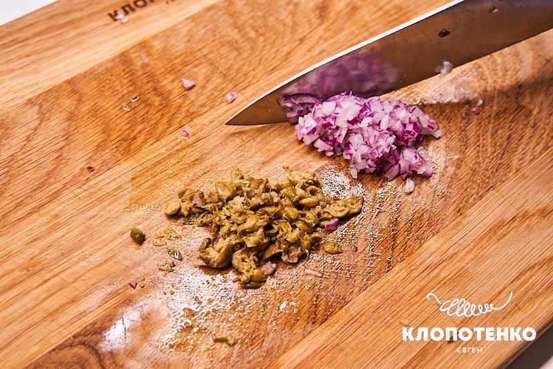 Нарежьте лук и каперсы