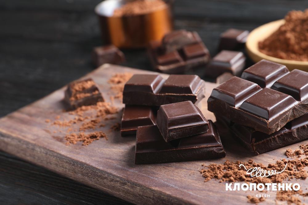 Шматочки чорного шоколаду лежать на дощечці