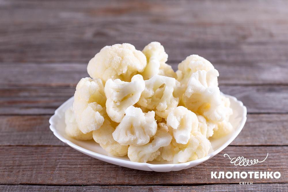 Заморожені суцвіття цвітної капусти лежать на тарілці