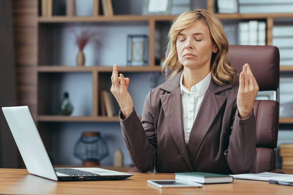 жінка медитує за робочим столом