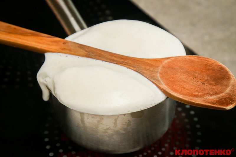 Каструля з молоком з дерев'яною ложкою